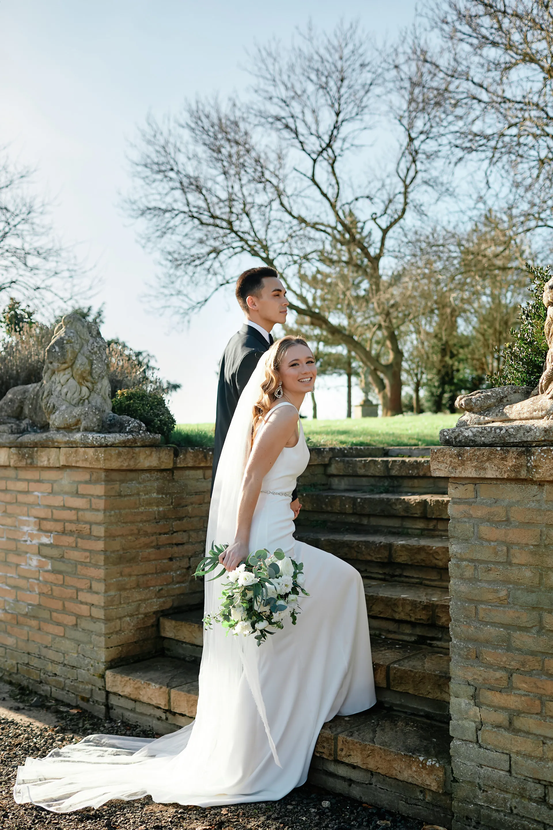 A couple walking up some stairs, the bride has a bouquet in their right hand