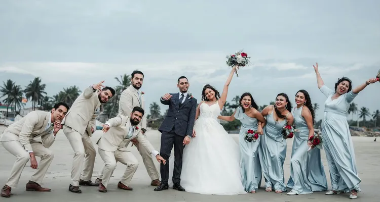a bride, groom and their wedding party standing next to each other on a beach, celebratory poses and excited faces
