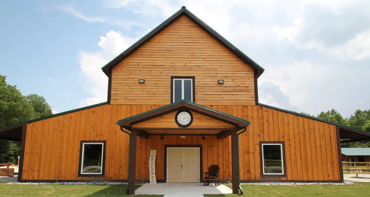 A wooden barn with a porch which has a clock facing forward