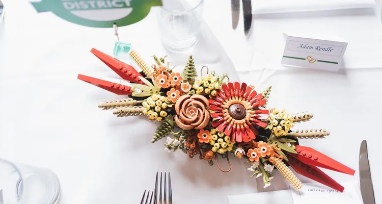 Wedding table set up with handmade place names, District Line roundal table name and Lego flowers with silver cutlery and clear glassware on white table linen