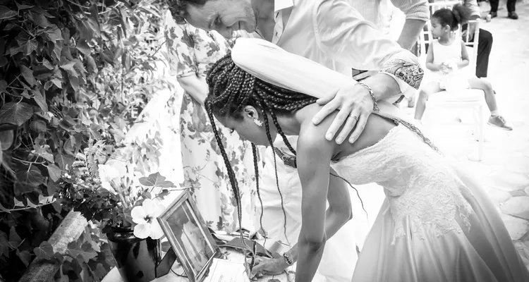 A black and white image of a newly married couple signing their certificate of marriage